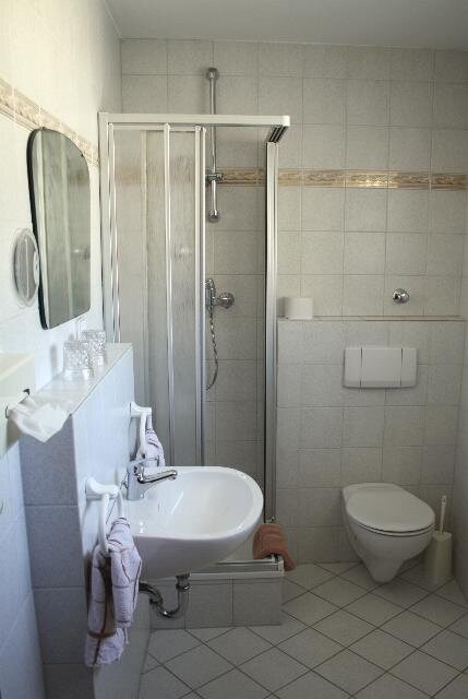 Badezimmer mit Dusche, Waschbecken und WC