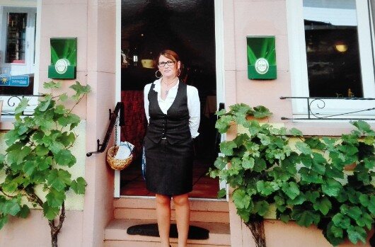 Gastgeberin Carla am Eingang des Hauses, umrankt von Weinreben