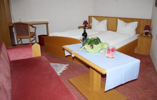 Doppelzimmer mit Holzbett und Couchtisch