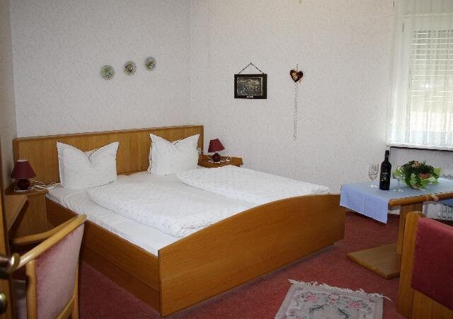 Doppelzimmer mit weißer Bettwäsche und Fenster